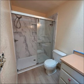 Remodeled bathroom with new shower, vanity and plank flooring